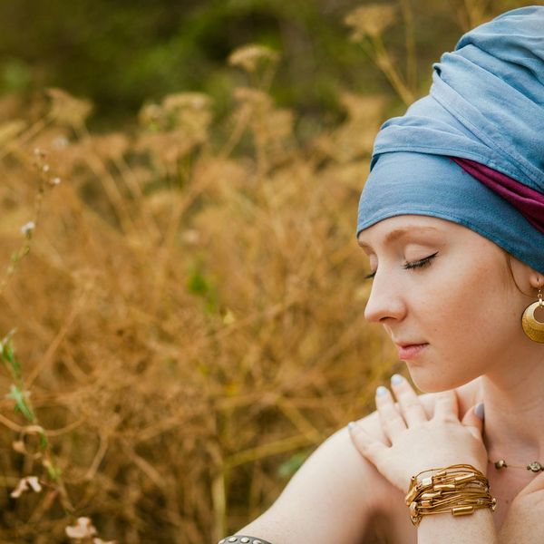 Person meditating peacefully outdoors with an amber color theme.